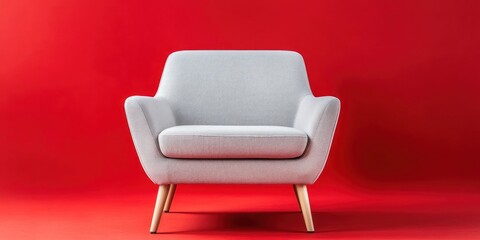 Modern gray armchair against a red background.