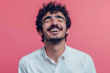 Fototapeta premium Man with curly hair laughs happily against pink background