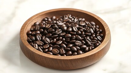 Fototapeta premium Roasted coffee beans in a wooden bowl on a marble surface.