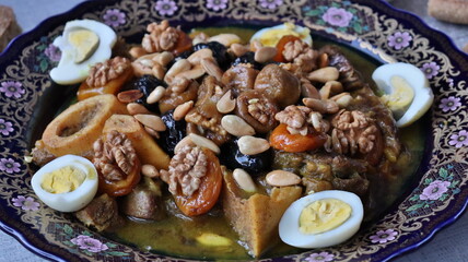 Traditional Moroccan Meat with Prunes, Nuts, and Boiled Eggs in Ornate Peacock Platter – Authentic North African Cuisine for Festive Occasions  

