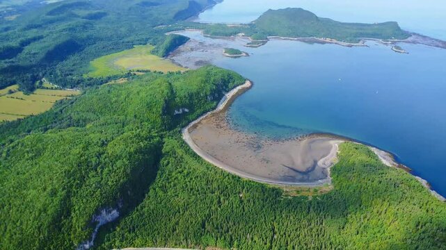 Panoramic aerial view of the rugged green cliffs and coastal terrain of Bic National Park along the St. Lawrence River near Rimouski, Quebec, Canada, during summer daylight.