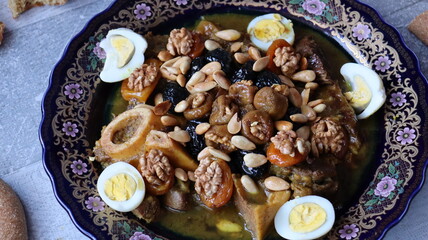 Traditional Moroccan Meat with Prunes, Nuts, and Boiled Eggs in Ornate Peacock Platter – Authentic North African Cuisine for Festive Occasions  
