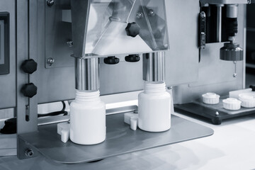 pharmaceutical industry, medicine pills are filling in the  bottle on production line machine conveyor at the medical factory. selective focus.