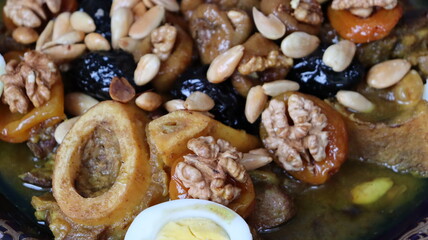 Traditional Moroccan Meat with Prunes, Nuts, and Boiled Eggs in Ornate Peacock Platter – Authentic North African Cuisine for Festive Occasions  
