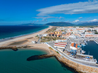 Aerial view of Tarifa, Spain, showing a sandy beach, deep blue Atlantic waters, a marina with...
