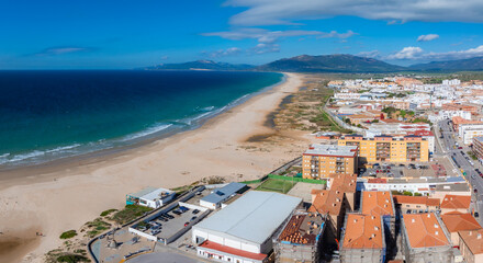 Tarifa's coastline stretches with the Atlantic Ocean on the left and the town's white and...
