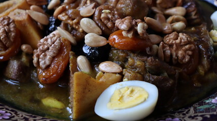 Traditional Moroccan Meat with Prunes, Nuts, and Boiled Eggs in Ornate Peacock Platter – Authentic North African Cuisine for Festive Occasions  

