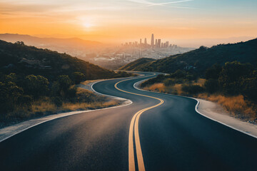 Winding road is leading through a mountain landscape toward a city skyline at sunset
