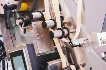 Fragment of the conveyor of sticking labeling machine. Abstract industrial background.