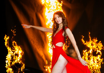 Fire and Grace: A young beauty in a red dress posing against a backdrop of flames