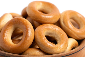 Bagels in wooden bowl on white background. Closeup.