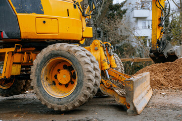 Modern excavator with a blade and pipe at a construction site on an overcast day. High quality photo