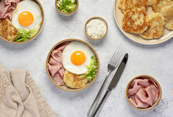 Food photography of fried eggs with potato pancakes, roast ham and spring onion; yogurt, breakfast, brunch