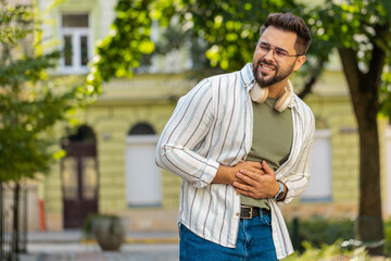 Caucasian young man traveler feeling sudden strong abdominal stomach ache gastritis problem. Upset...