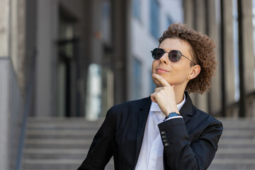 Portrait of Caucasian puzzled businessman professional standing outdoors deep in thoughts thinking...