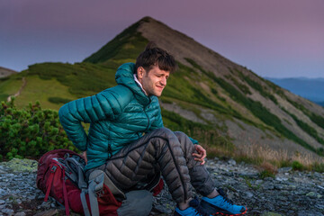 Travelling Man Holds His Lower Back with an Expression of Pain on His Face