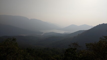 Fototapeta premium Landscape view of misty hills and valleys with distant mountains fading into a hazy sky