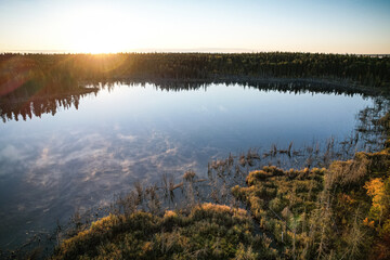 A lake with a sun reflecting on the water
