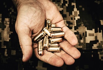 hand holds 
 bullets for a gun