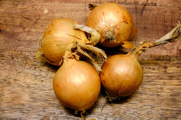 Onions lying on a wooden log. Onions are a vegetable with great nutritional and medicinal properties.