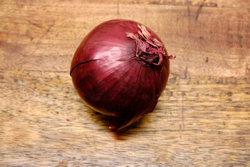 Onions lying on a wooden log. Onions are a vegetable with great nutritional and medicinal properties.