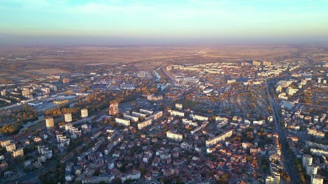 Aerial drone footage of a sunset over the city of Plovdiv in Bulgaria. Ancient city of Filipopolis filmed from above on a warm autumn afternoon. European city seen from a helicopter establishing shot.