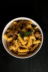Italian pasta with chicken in a bowl. on a black background. lunch .italy