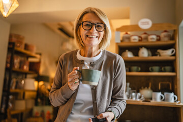 woman entrepreneur use mobile phone and drink coffee at rustic shop