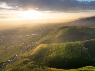 Drone view of clouds at sunset. Beautiful clouds in the sky, haze covered the town. Summer evening...