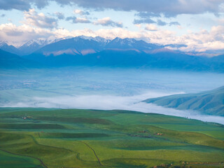 Drone view of mountains at sunset. Beautiful blue clouds covered the earth. Evening landscape.