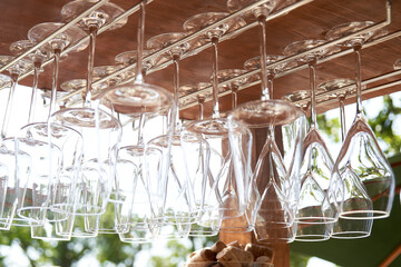Close-up of an upside-down hanging wine glass. Outdoor bar counter