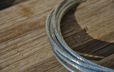 Obraz premium steel cable on a wooden background close-up. selective focus