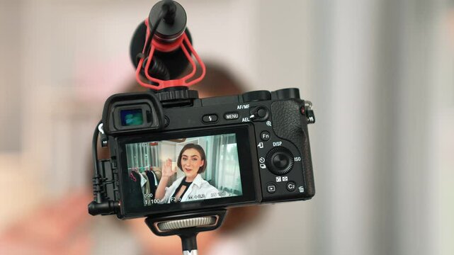 Rear view behide camera screen display woman influencer shoot vlog video review clothes prim social media or blog. Girl with apparel studio lighting for live streaming marketing recording session