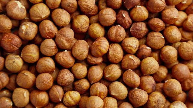 Pile of hazelnuts without shell rotating. Texture of hazelnut kernels. Natural vegetarian food. Vegan snack. Production line. Organic food. Close-up in 4K, UHD