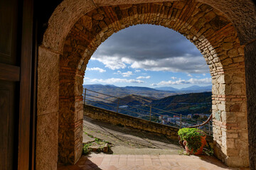 A stone arch overlooking the landscape of Calitri, a town in Campania, Italy.