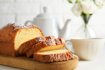 Freshly baked sponge cake on white wooden table, closeup