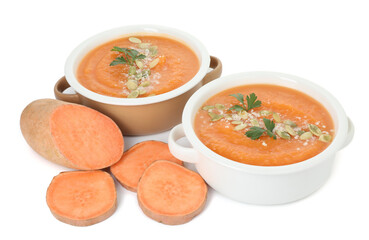 Delicious sweet potato soup with pumpkin seeds in bowls and fresh vegetable isolated on white