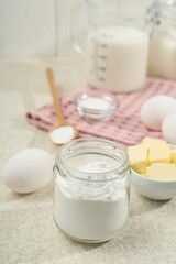 Baking powder and other ingredients for making dough on table, closeup