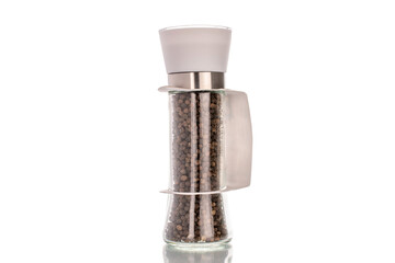 Black peppercorns in a glass grinder, macro, isolated on a white background.