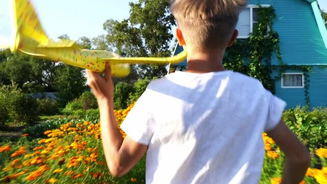 a boy in nature launches a glider plane into the sky