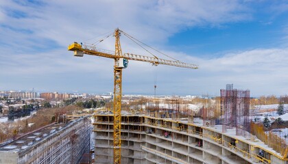 고층 건물 공사 현장에서 타워크레인이 자재를 올리고 있는 장면