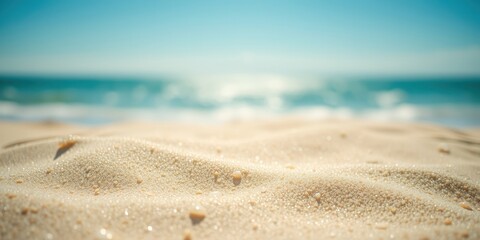 Close-up of wet sand on a beach with a blurred background of blue ocean and sky