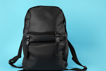 Naklejka premium Black backpack on blue background. Black backpack with blue and black background. Black backpack blue background style bag. Black backpack with a black bag style lifestyle.