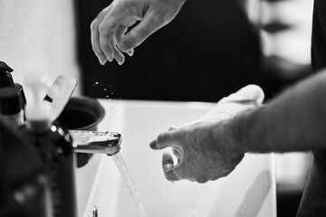 Hands washing with water at a sink in a simple setting