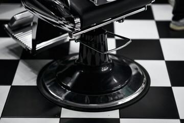 Classic barber chair on black and white checkered floor in barbershop