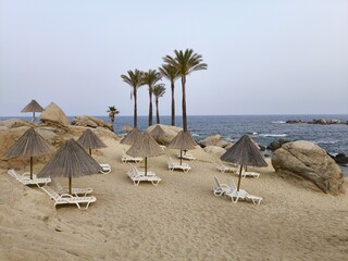 sandy beach in Sardinia with umbrellas and sunbeds