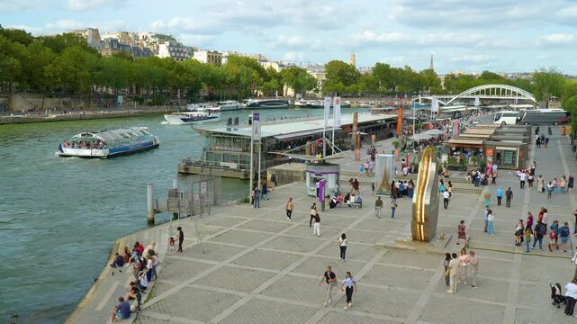 Experience the vibrant atmosphere of Paris with this enchanting stock footage. The clip captures tour boats traveling up the scenic Seine River, providing a picturesque view of the iconic city. 