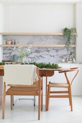 Minimalist kitchen with wooden dining table and greenery decor