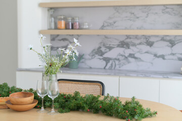 Festive dining table with floral decor and greenery garland