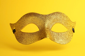 Beautiful golden carnival mask on yellow background